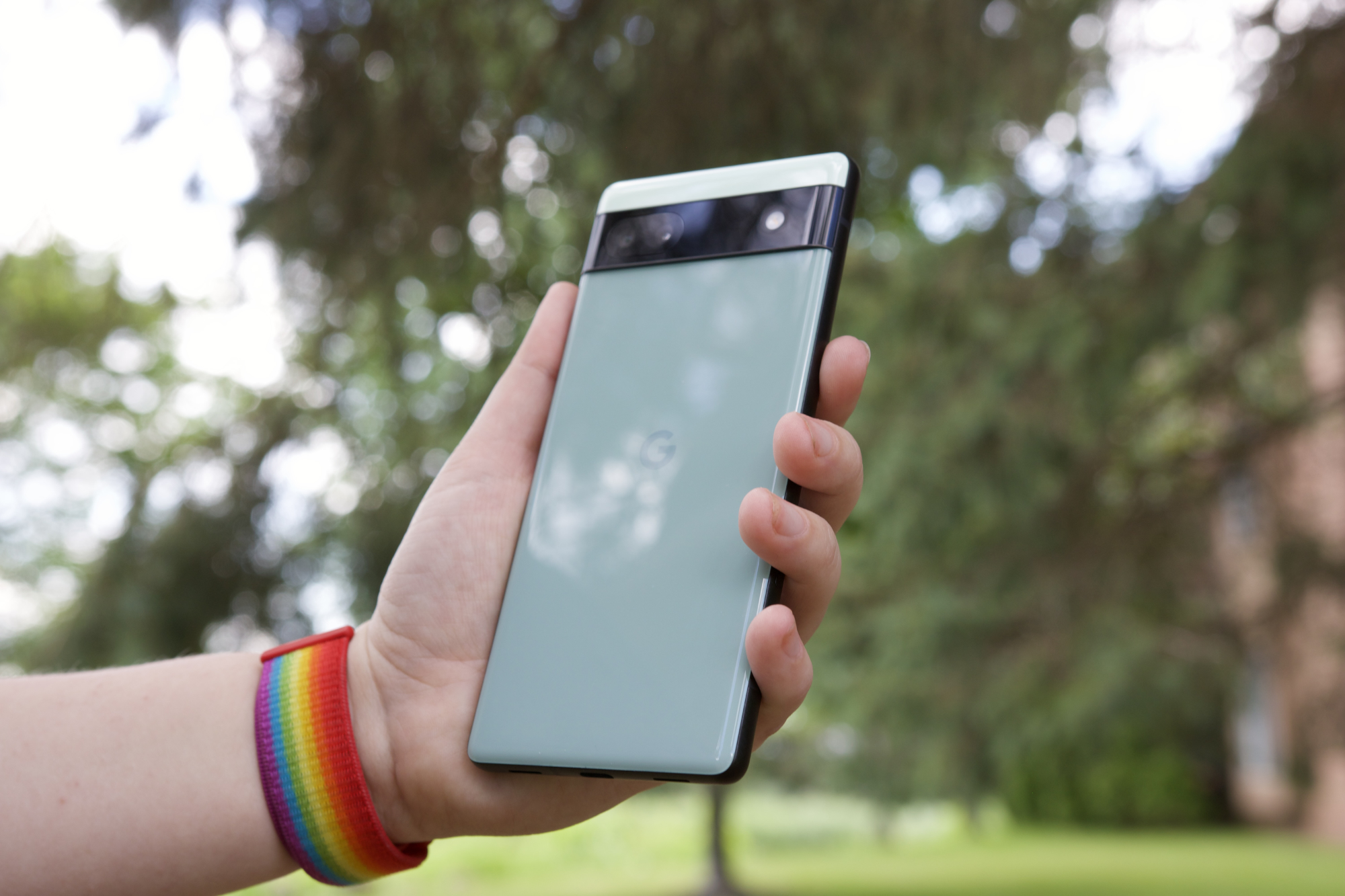 Someone outside holding the Pixel 6a. We see the back of the phone.