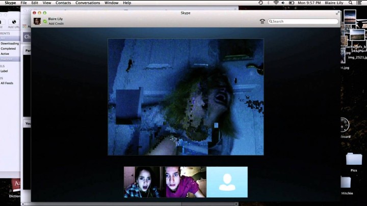 A teenager girl screams in terror in a Skype window while her friends helplessly watch.