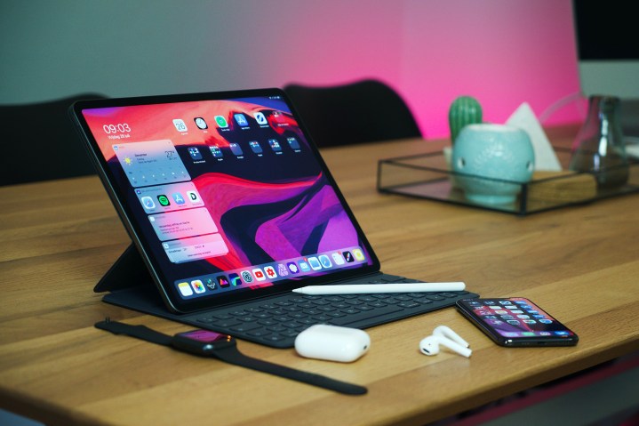 iPad Pro on a desk with other Apple devices and accessories.